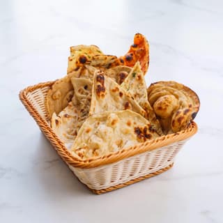 Naan basket butter charred bubbles garlic plain laccha bread overhead — naan hero photography