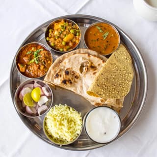 Indian thali platter steel bowls curries rice dal naan rice overhead — thali hero photography