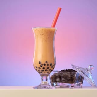 Pearl milk tea with tapioca boba against a lavender backdrop — bubble tea shop photography