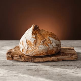 Crusty sourdough boule on weathered wood planks — farmers-market sign food photography