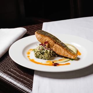 Pan-seared salmon with crisp skin on white linen — bistro main course food photography