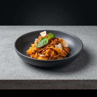 Pappardelle with beef ragù in a charcoal bowl — Italian restaurant food photography