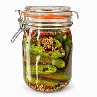 Unlabelled clear glass jar of whole dill pickles in green-gold brine with dill and garlic, on a seamless pure white background