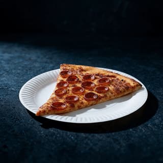 One large pepperoni pizza slice on a plain paper plate with cupped pepperoni and browned cheese