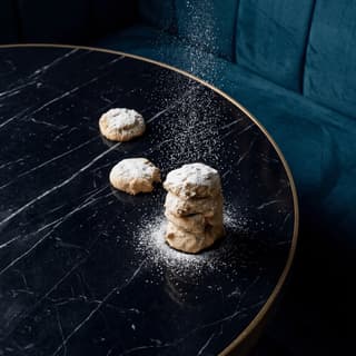Matcha sablé vertical cookie tower on dark velvet — Japanese patisserie cookie photography