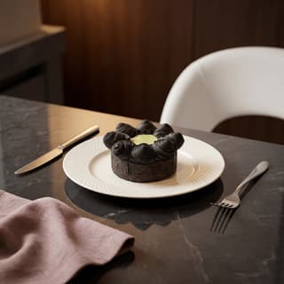Black charcoal croissant cake with oozing emerald matcha cream center — modern Korean patisserie photography