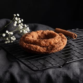 Old fashioned cake donut cinnamon sugar coating cooling rack — classic donut hero photography