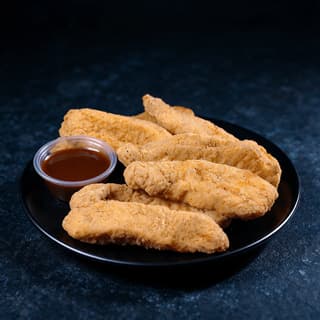 Golden breaded chicken tenders in a paper boat with one dipping sauce cup on dark slate