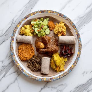 Ethiopian injera platter multiple stews overhead doro wat shiro gomen — injera platter hero photography