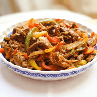 Ethiopian tibs beef cubes sauteed peppers onion sizzle clay dish — tibs hero photography
