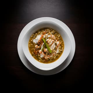 Golden khao soi curry noodle soup with crispy noodle crown — Northern Thai food photography