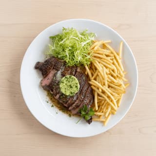 Steak frites seared steak golden fries herb butter bistro plate overhead — steak frites hero photography