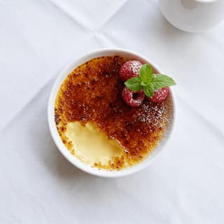 Creme brulee cracked caramelized sugar crust custard ramekin vanilla berries — creme brulee hero photography