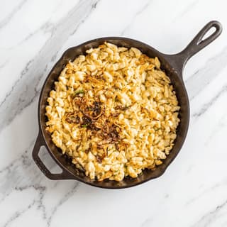Kasespatzle german cheese spaetzle crispy fried onions chives skillet overhead — spaetzle hero photography