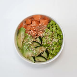 Fersk tunfisk-poke-bowl med avokado, edamame og sesam på marmor — matfotografering for ghost kitchen bowl-merke