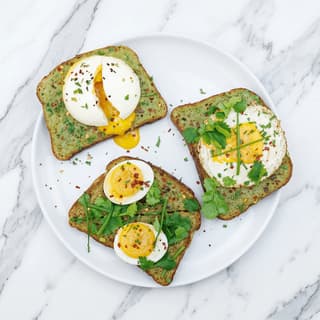 Avokadotoast-trio med posjerte og løpeeggede egg på marineblå tallerken — matfotografering for brunsjlevering