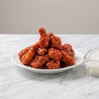 Korean fried chicken yangnyeom red glaze double fry sesame scallion plate — korean fried chicken hero photography