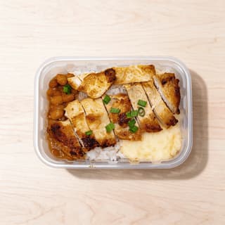 Single glass meal prep container filled with sliced chicken, quinoa and roasted vegetables in neat sections