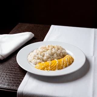Mango sticky rice με κρέμα καρύδας, φρέσκια βεντάλια μάνγκο και σουσάμι σε πιάτο — κεντρική φωτογραφία mango sticky rice