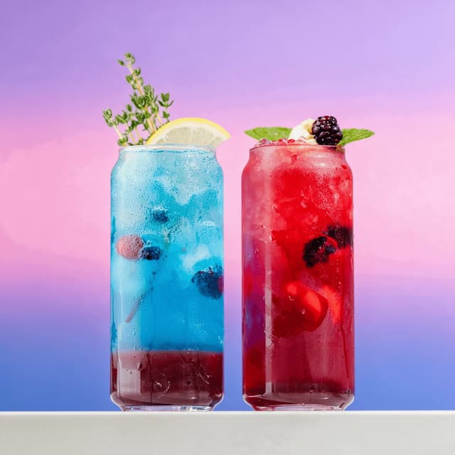 Blue lemonade and berry fizz mocktails on a lavender gradient — zero-proof menu photography