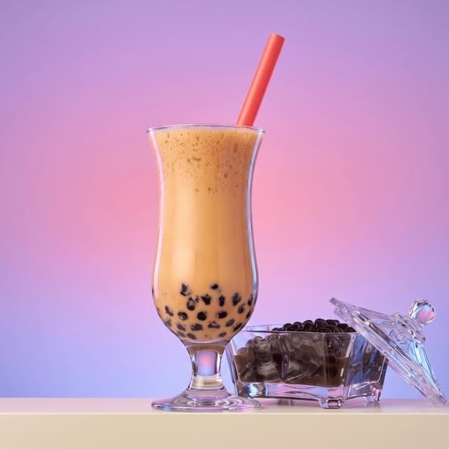 Pearl milk tea with tapioca boba against a lavender backdrop — bubble tea shop photography