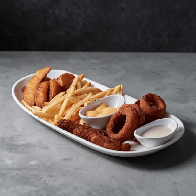 Fries, onion rings and mozzarella sticks with two dips — fast food sides photography