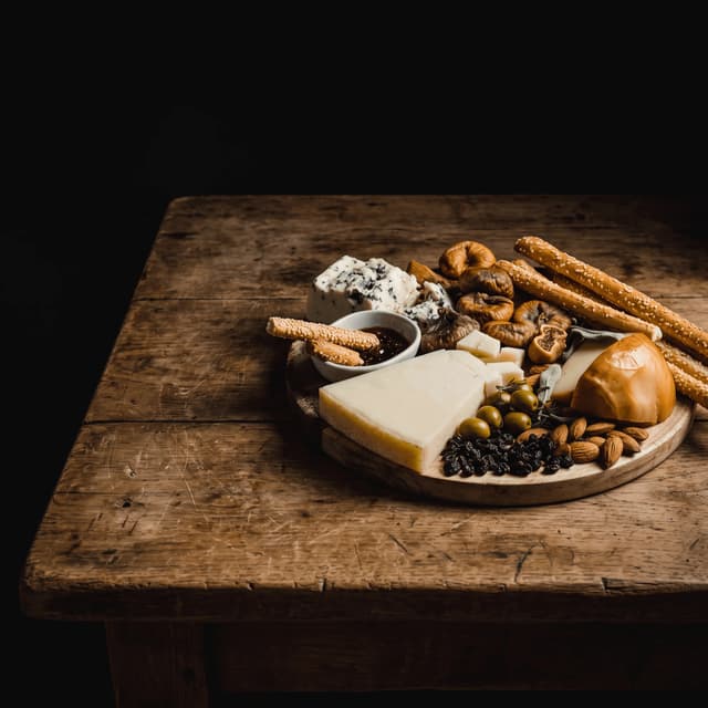Cheese board with blue cheese, figs and grissini on aged wood — tasting event poster photography
