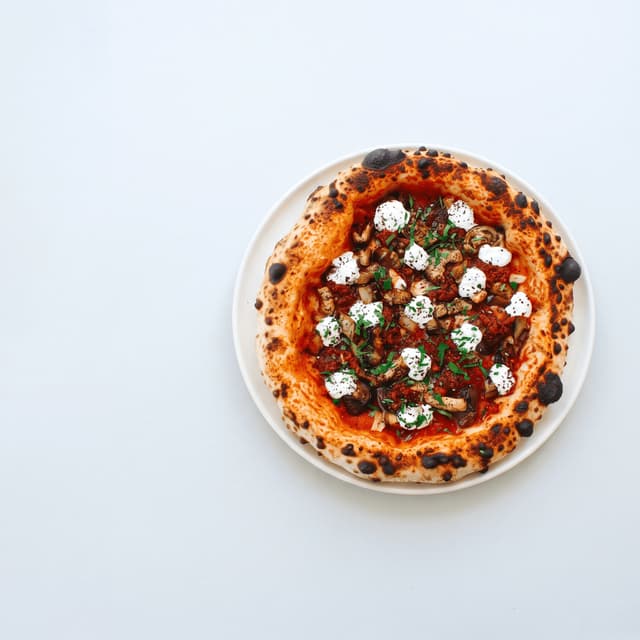 Wood-fired pizza with sausage and ricotta on white — wide web banner food photography
