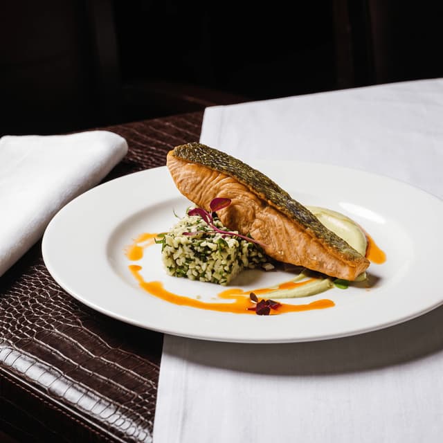 Pan-seared salmon with crisp skin on white linen — bistro main course food photography