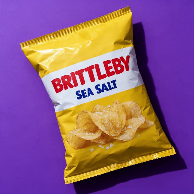 Sea salt kettle chips bag on a violet backdrop — snack brand food photography