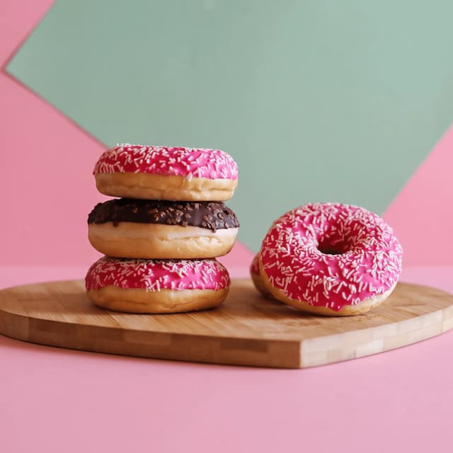 Sprinkled pink and chocolate donuts on a bamboo board — Instagram story food photography