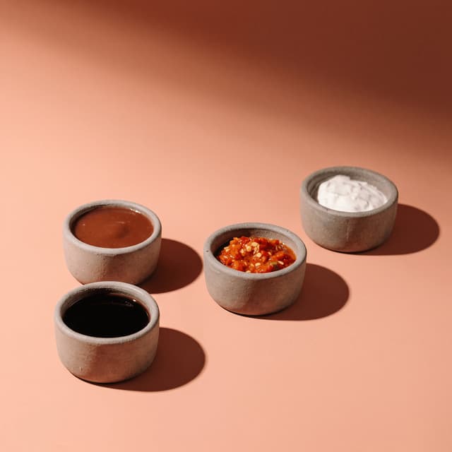 BBQ sauce, chili salsa, soy glaze and sour cream on peach — sauce maker photography