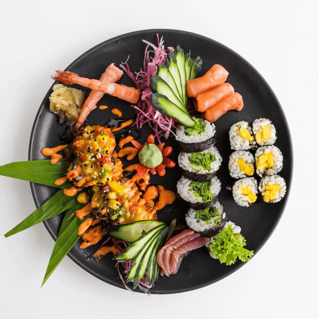Sushi platter of maki rolls, sashimi and shrimp on white from above — sushi ad photography
