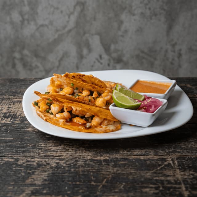 Shrimp tacos with lime and pickled onion on dark weathered wood — taco night ad photography