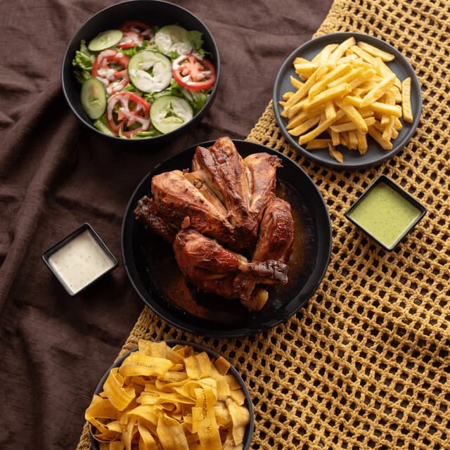 Rotisserie chicken with fries, salad and plantain chips from above — family meal flyer photography
