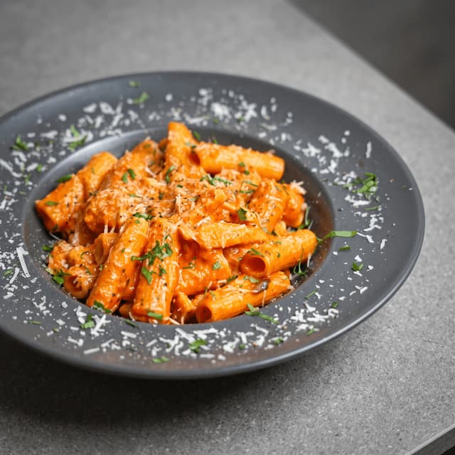 Rigatoni alla vodka su parmezanu ant pilko akmens – maisto fotografija dienos pasiūlymo plakatui