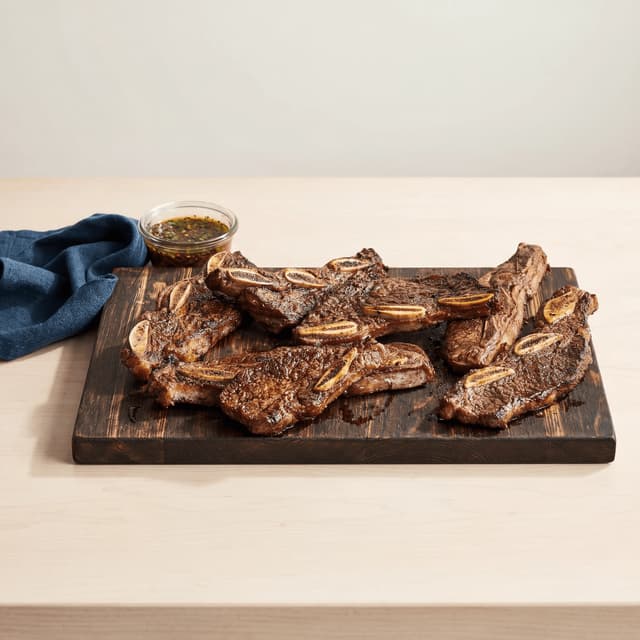 Asado de tira argentine short ribs cross cut char grilled coarse salt board — asado de tira hero photography