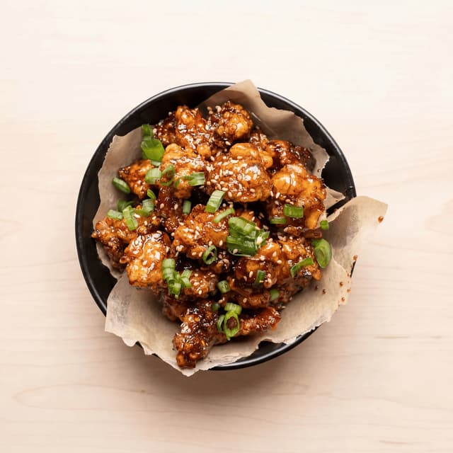 Modern asian fried chicken crispy glaze sesame scallion bun plate — asian fried chicken hero photography