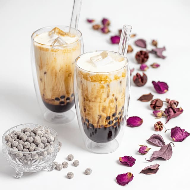 Bubble tea milk tea tapioca pearls tall glass layered gradient condensation — bubble tea hero photography
