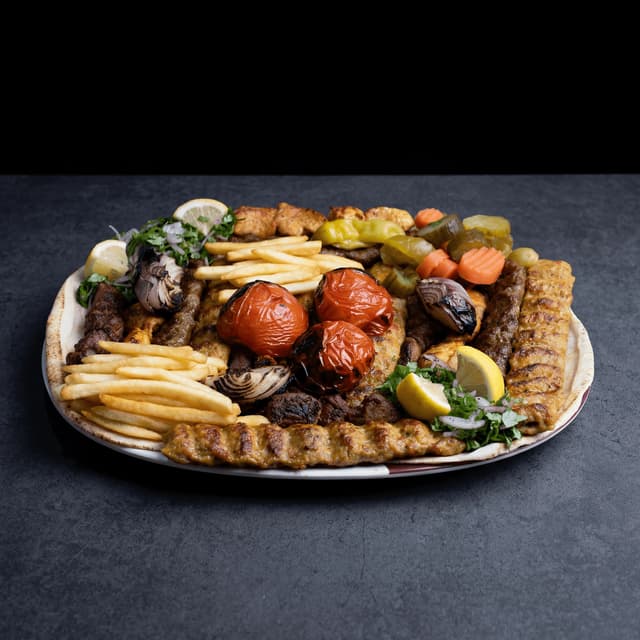Texas three-meat combo tray with moist brisket pork ribs sausage mac-and-cheese on cafeteria tray with pink butcher paper — Central Texas BBQ photography