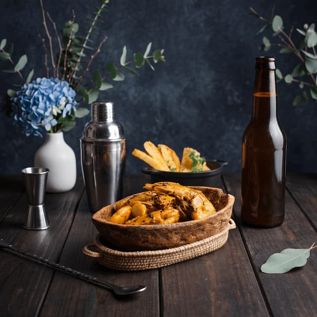 Fresh hop winter seasonal IPA in pint glass with fresh hop cones and pine on pine plank — seasonal beer release photography