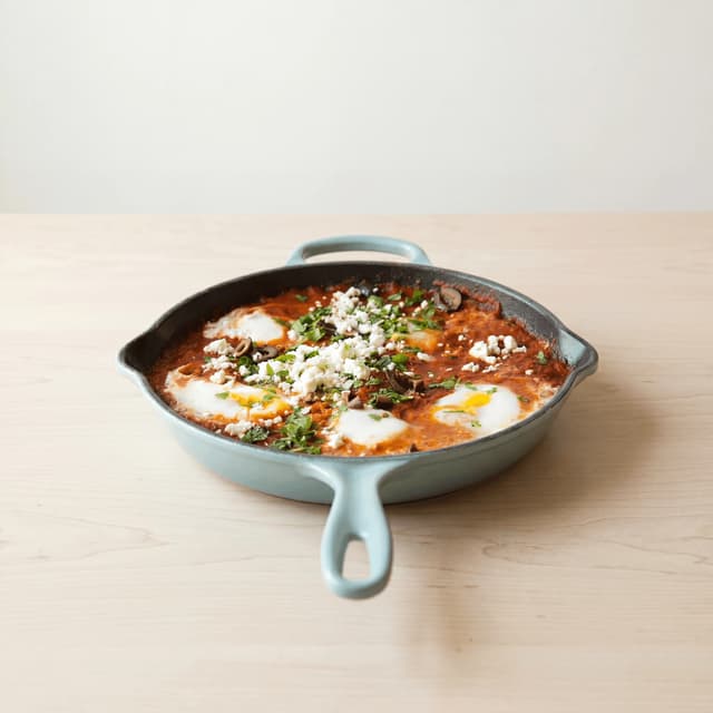 Shakshuka cast iron skillet poached eggs tomato sauce parsley — shakshuka hero photography