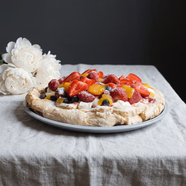 Krem şanti ve yaz meyveleriyle bütün pavlova tabağı — pavlova pasta fotoğrafçılığı