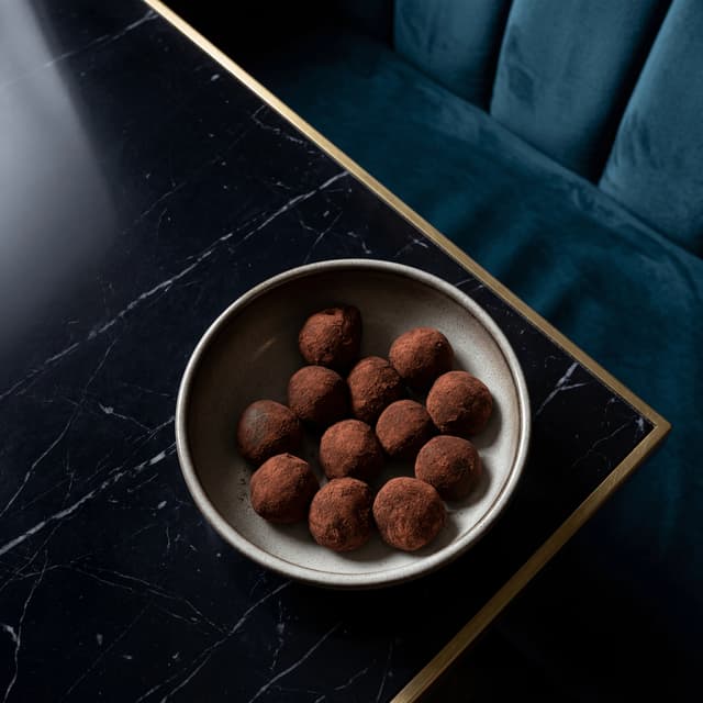 Hand-rolled cocoa-dusted dark chocolate truffles assortment — truffle bonbon chocolatier card photography