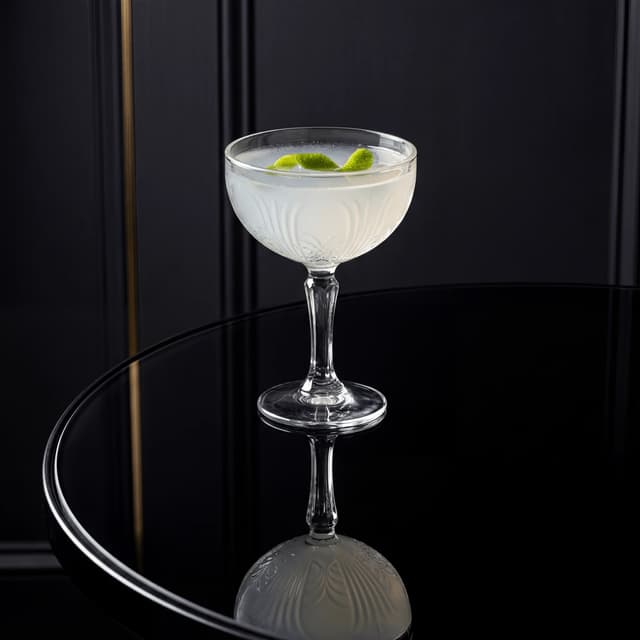 Daiquiri cocktail coupe glass lime twist crystal ice — craft cocktail hero photography