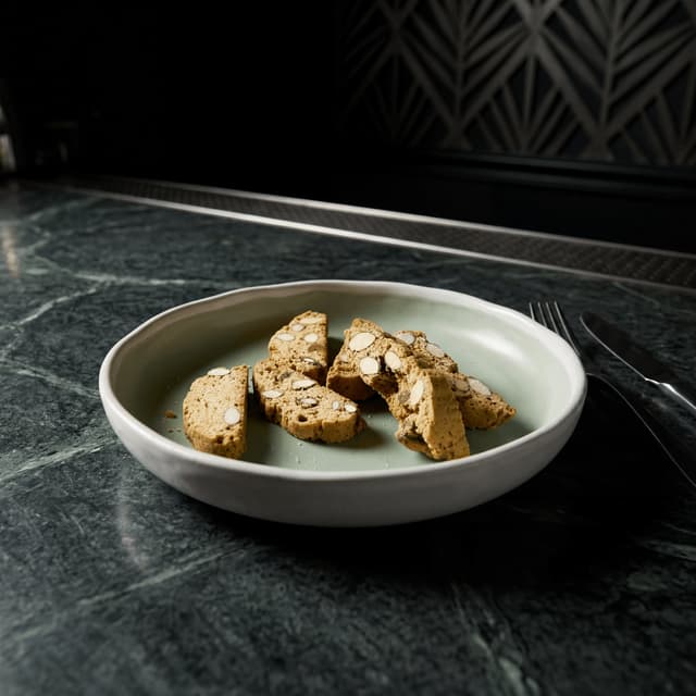 Abundant Tuscan biscotti tower stacked on dark leather surface — Italian biscotti photography