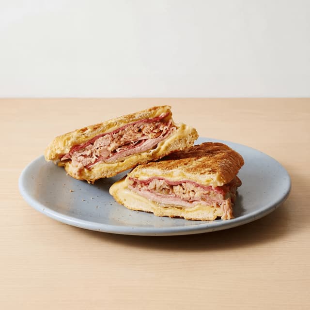 Cuban sandwich cubano cross section ham pork Swiss pickle plancha pressed board — cuban sandwich hero photography