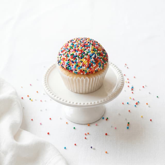 Vanilija cupcake prekriven šarenim posipom nonparelica — fotografija cupcakea iz pekare