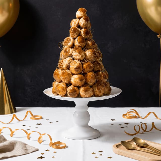 Wedding croquembouche tower of caramel-glazed choux puffs with sugared almonds and spun sugar — classical French celebration cake photography
