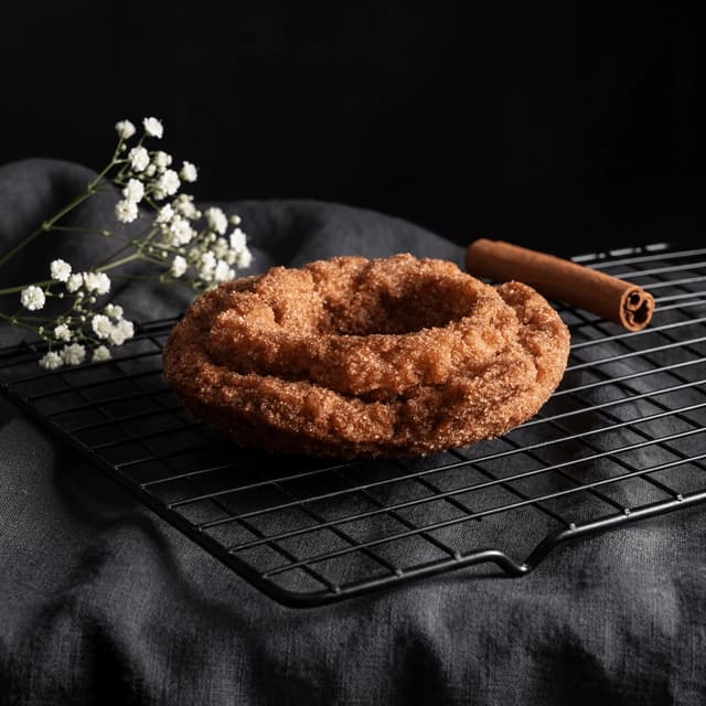 Old fashioned cake donut cinnamon sugar coating cooling rack — classic donut hero photography